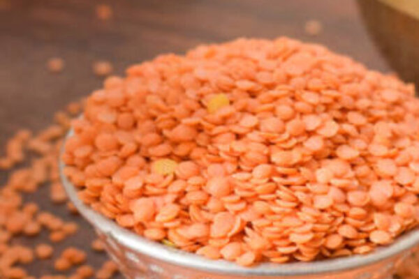 Dry Split Red Lentils in a Silver bowl on wooden old Table. rustic style